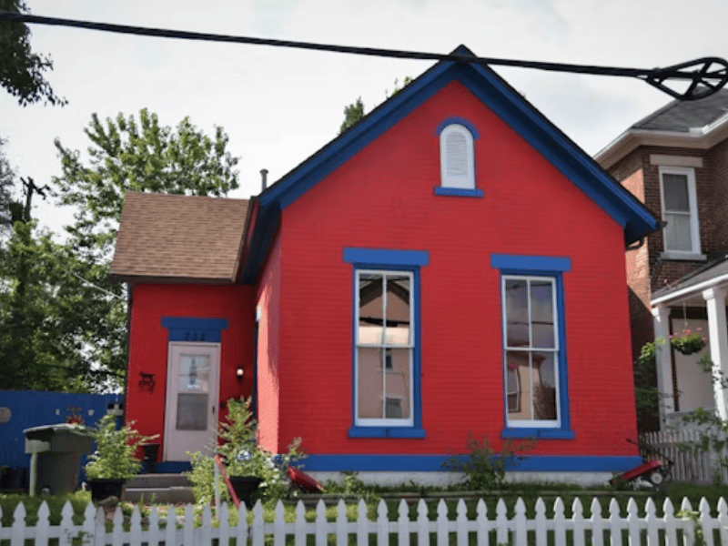 Bold exterior transformation - dark green house with white trim