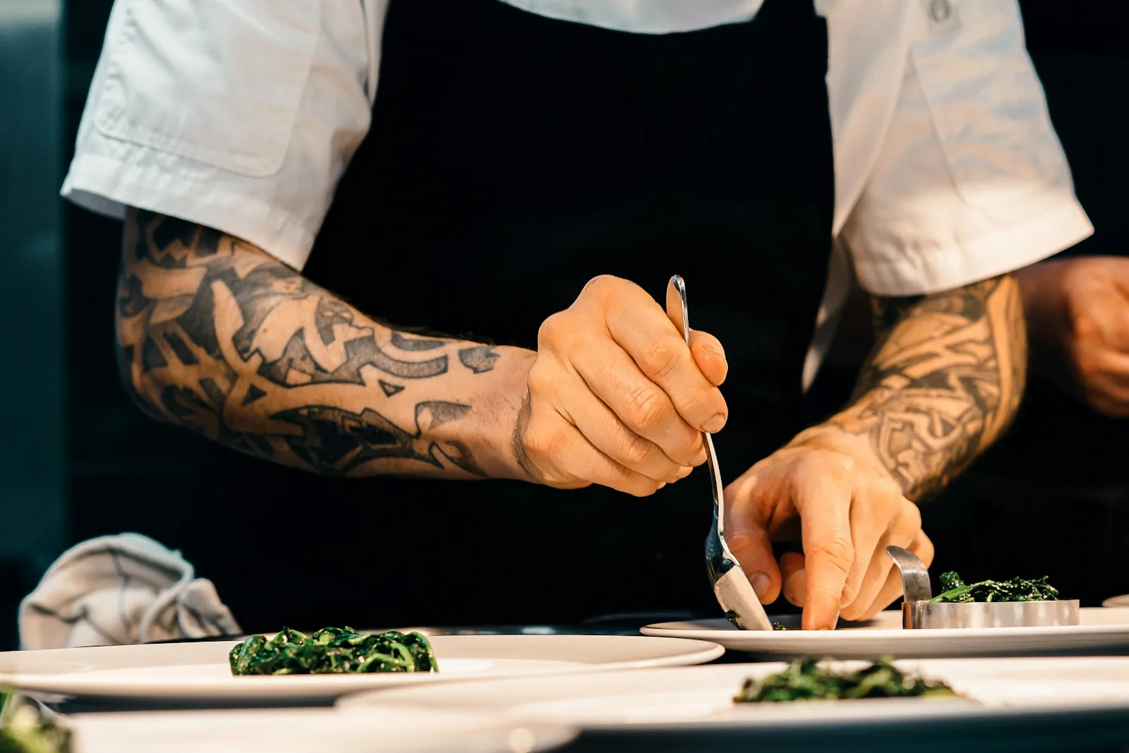 Chef's hands plating a dish with precision