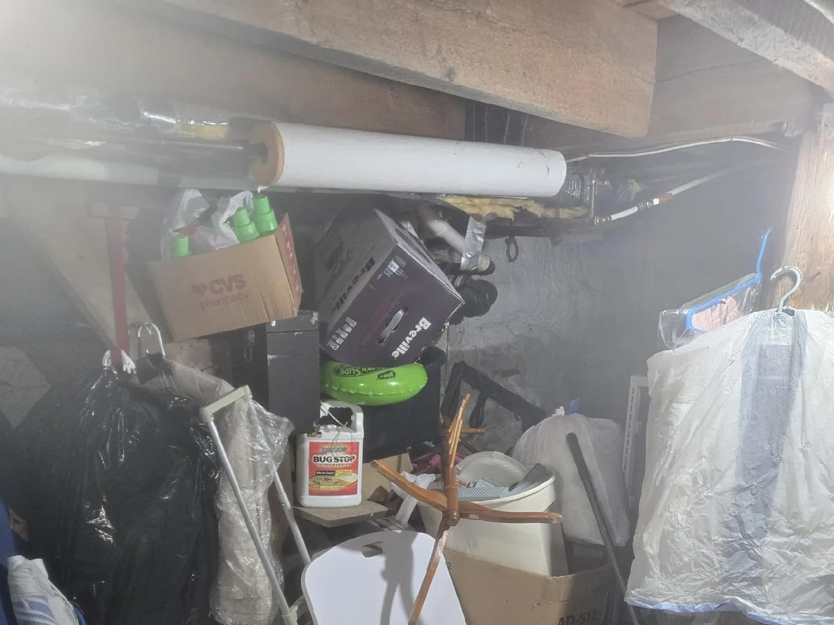 Cellar packed with boxes, totes, and household items before a cleanout