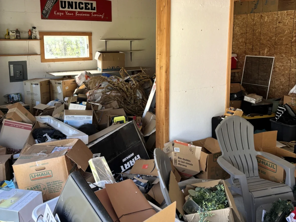 Garage packed wall to wall with boxes and household items before a cleanout